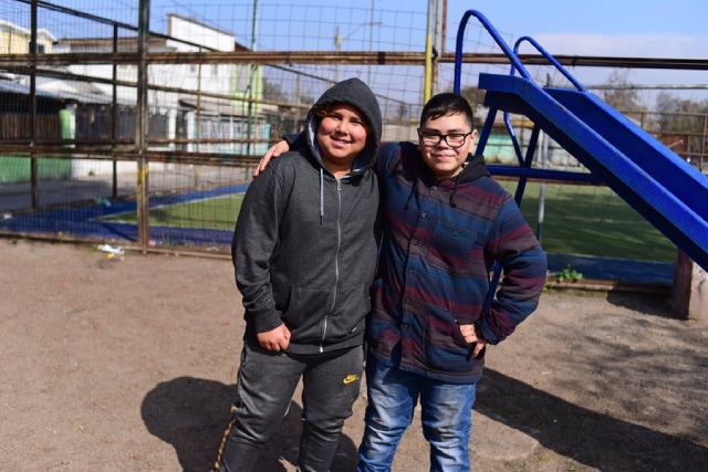 Amigos abrazados y sonriendo en un parque